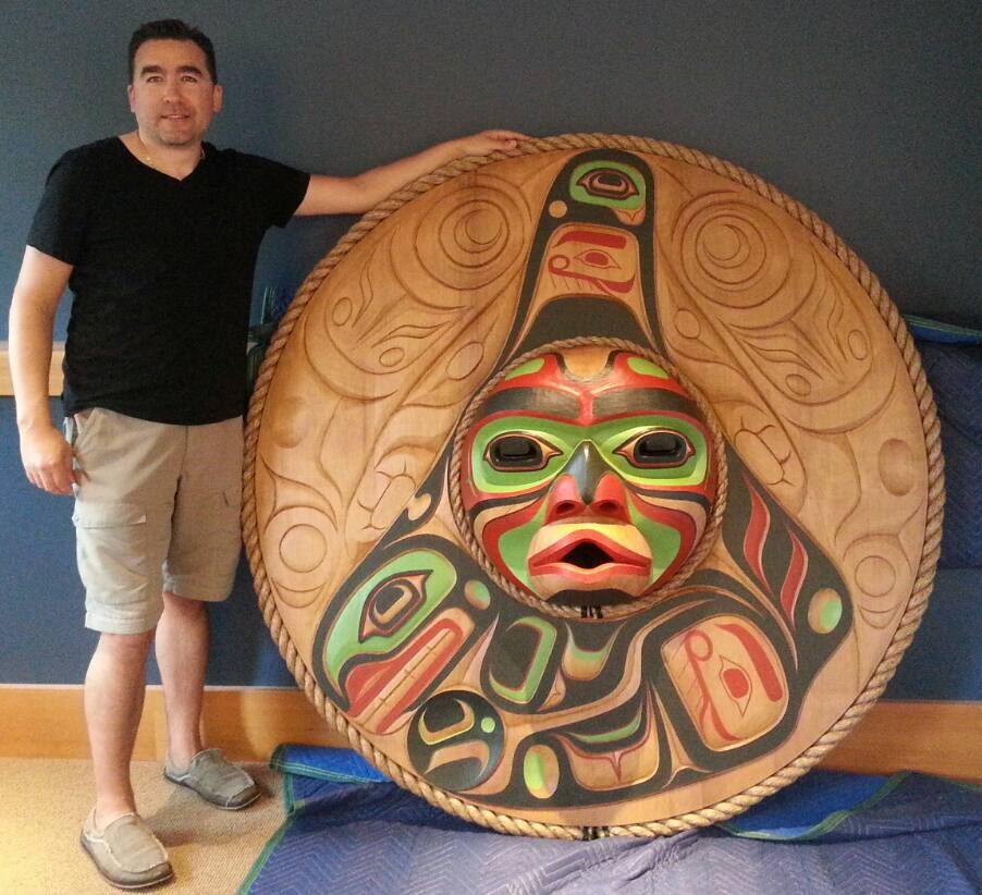 Jason Henry Hunt beside a large round moon mask panel