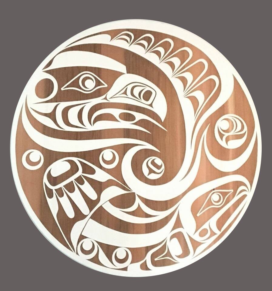 Round cedar panel with the eagle and salmon chase design in white formline on natural wood