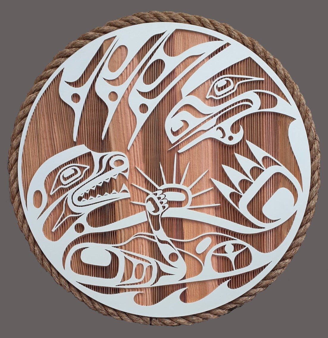 Round cedar panel with otter, raven and sunburst in white formline