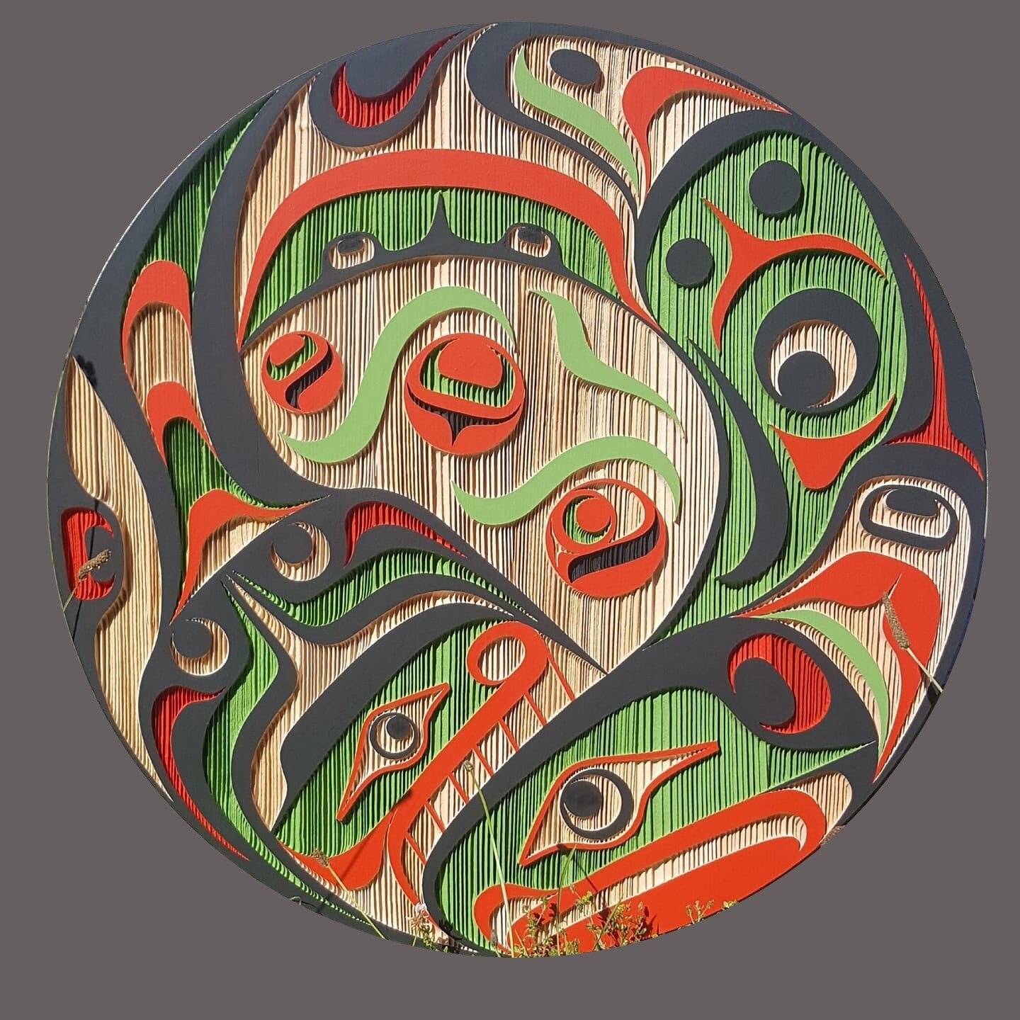 Round panel of the salmon and egg design painted in black, red and green