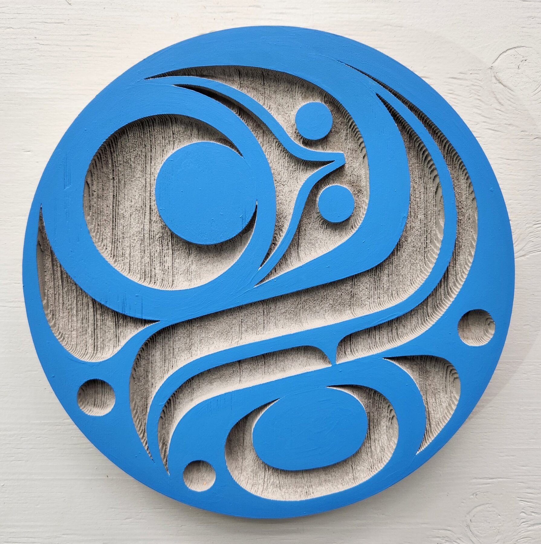 Blue cut-through round salmon egg panel mounted on a white wall