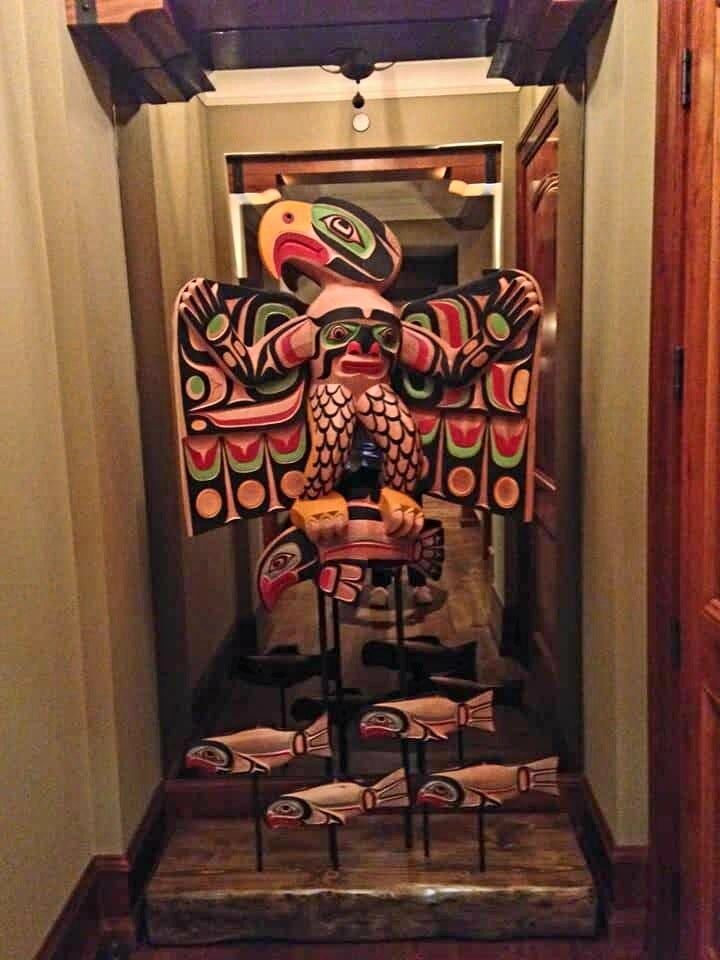 Thunderbird and man sculpture with a school of carved salmon